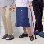 Senior wearing supportive non slip shoes and properly fitted clothing to reduce fall risk and improve stability.