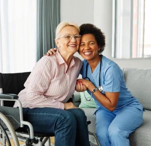 Occupational therapist hugging elderly woman in wheelchair, representing compassionate care, support, and safe aging in place