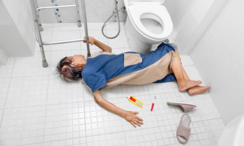 Elderly woman lying on bathroom floor after a fall, illustrating the importance of home safety and fall prevention